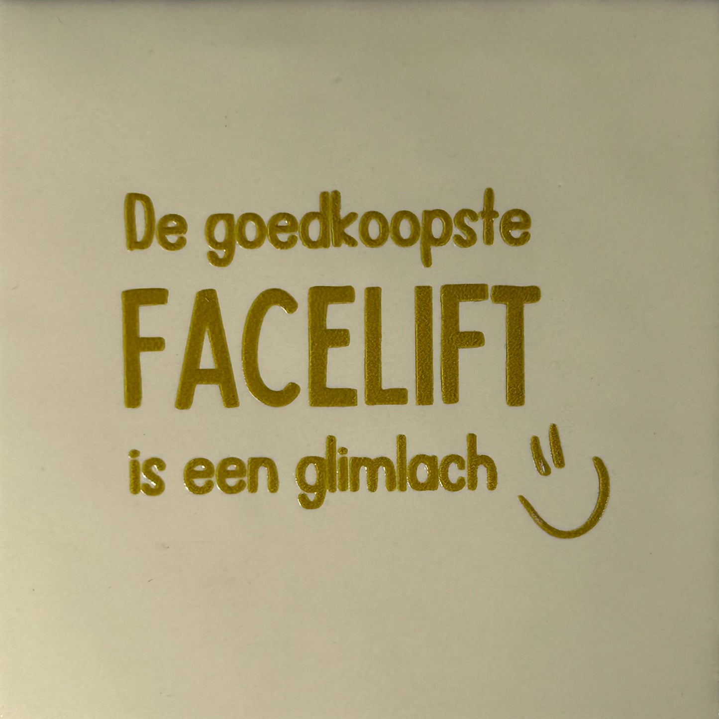 Quote tegeltje 'de goedkoopste facelift is een glimlach' creme/goud