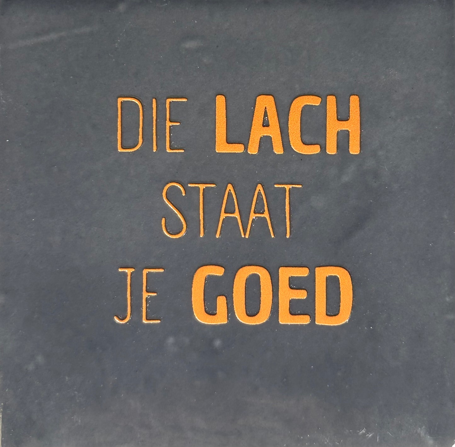 Quote tegeltje 'die lach staat je goed' antraciet/oranje