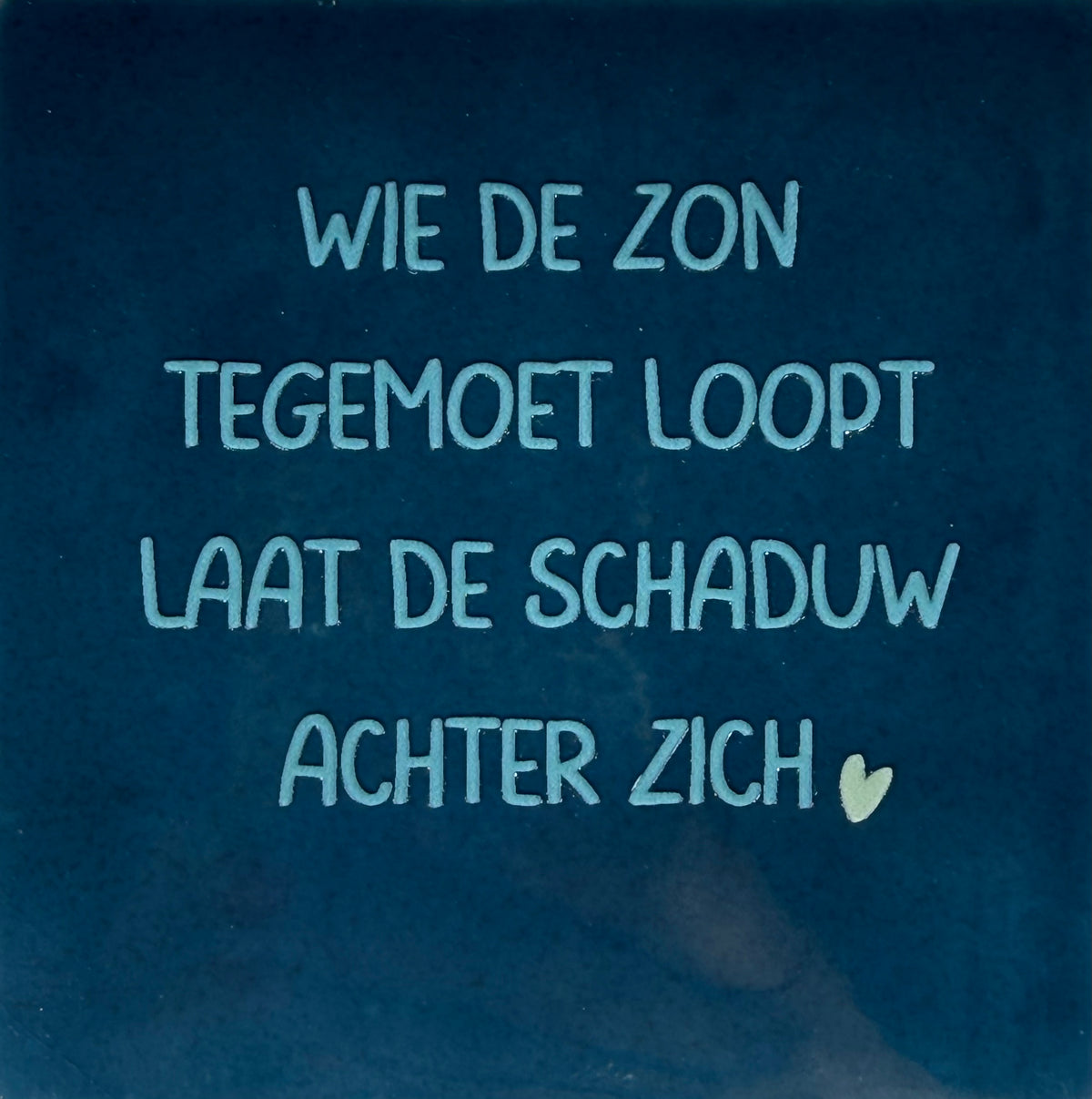 Quote tegeltje 'wie de zon tegemoet loopt laat de schaduw achter zich' donkerblauw/warmblauw(lichtgroen)